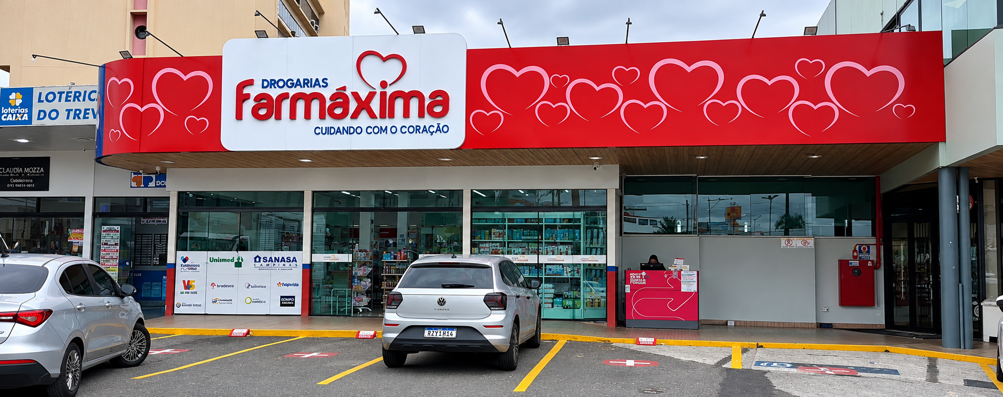 Fachada das Drogarias Farmáxima, com entregador saindo para uma entrega pelo iFood